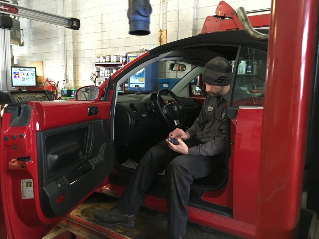 Zach checking the diagnostics on a red VW Beetle